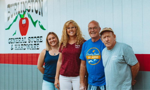 Burlington General Store staff in front of a Burlington General Store sign.